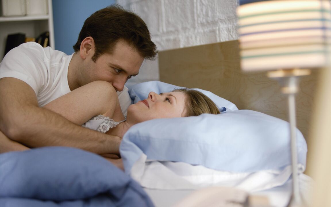 a woman in bed with a man who enlarged his penis